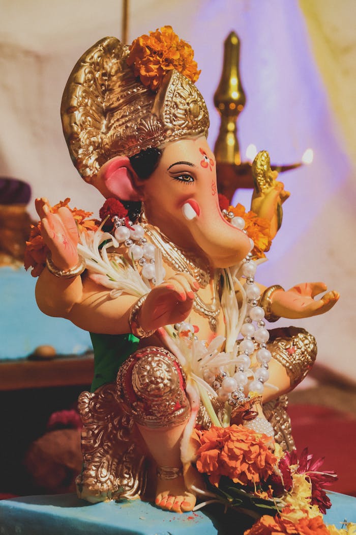 Beautifully adorned Ganesha statue with vibrant flowers, representing traditional Hindu culture.